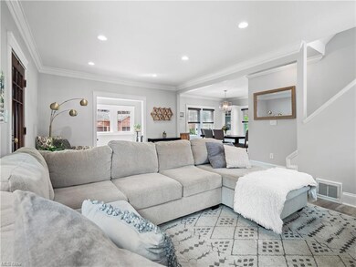 Living room with ornamental molding and light hardwood flooring