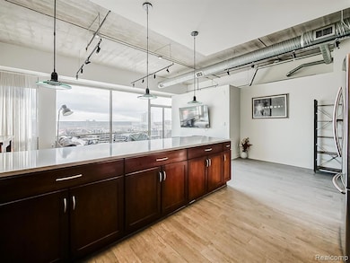 Kitchen featuring hanging light fixtures, light wood finished floors, track lighting, and freestanding refrigerator