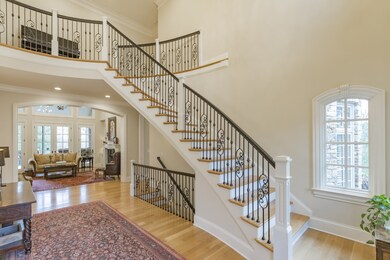 Beautiful iron doors with leaded glass open to this elegant two story foyer with an exquisite floating stairwell!