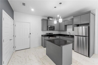 Kitchen featuring gray cabinets, visible vents, a sink, marble finish floor, and stainless steel appliances