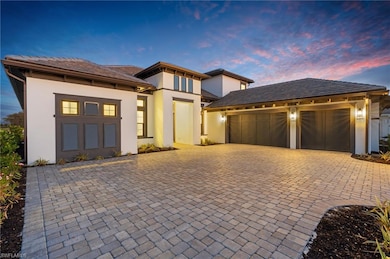 Prairie-style home featuring a garage, stucco siding, and driveway