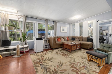 Living area featuring vaulted ceiling and wood finished floors