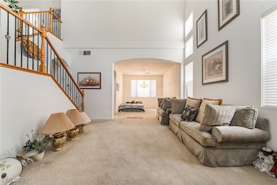 Living area with arched walkways, carpet, a high c