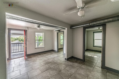 Spare room with ceiling fan, a textured ceiling, 