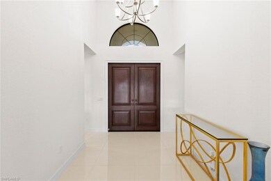 Foyer featuring a chandelier, tile patterned floors, and a towering ceiling