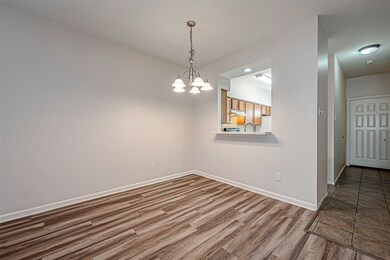 Dining room has a chandelier with frosted glass sh