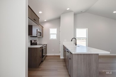 Kitchen with appliances with stainless steel finishes, modern cabinets, a peninsula, light countertops, and light wood finished floors