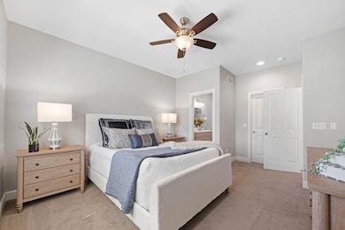 Bedroom featuring carpet, ceiling fan, ensuite bath, and recessed lighting