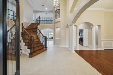 A stunning entry greets you with elegant arches, stately columns, a timeless curved wrought iron stair case with refinished wood stairs and freshly painted interior throughout the home.