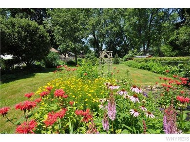 Exterior Front. Established flower and garden area