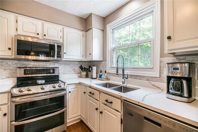 New quartz countertops, under cabinet sink and faucet, and freshly finished cabinets with new hardware.