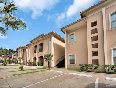 View of property with uncovered parking and stairway