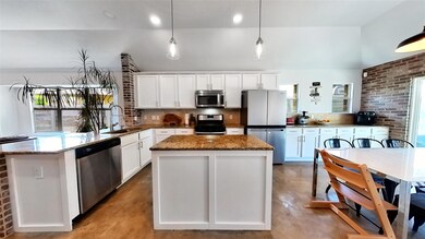 Kitchen with concrete flooring, appliances with s