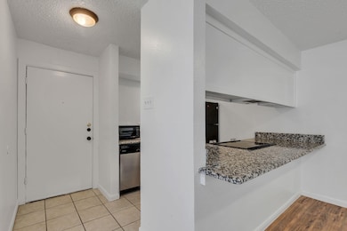 Kitchen with black cooktop, a textured ceiling, li