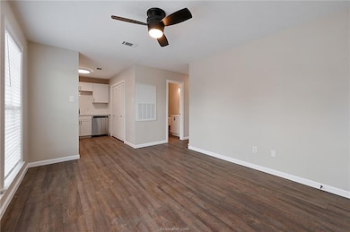 Unfurnished living room featuring dark hardwood /