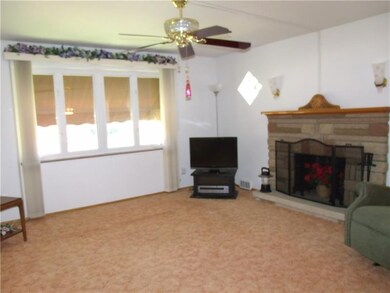 Living room with large window overlooking front ya