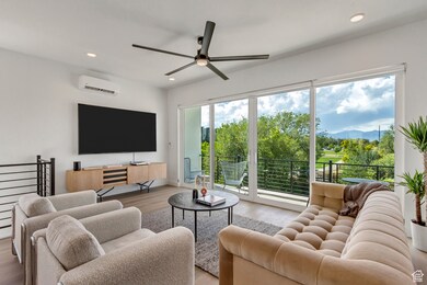 Living room featuring recessed lighting, wood finished floors, ceiling fan, and a wall mounted AC