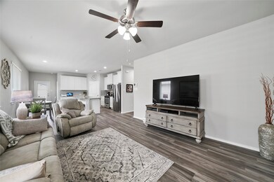 The family room is spacious with a large wall for entertainment center. Ceiling fan. Open to the dining area and kitchen.