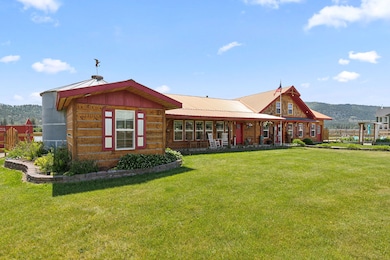 View of front of home with a mountain view, a porch, and a front lawn