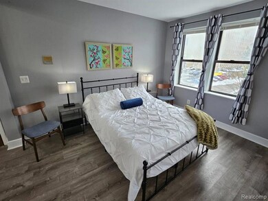 Bedroom with dark wood finished floors and baseboards