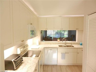 Kitchen featuring sink, light stone counters, stai