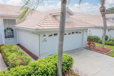 View of side of home with an attached garage, conc