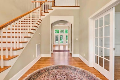 Entryway with wood finished floors, a high ceiling