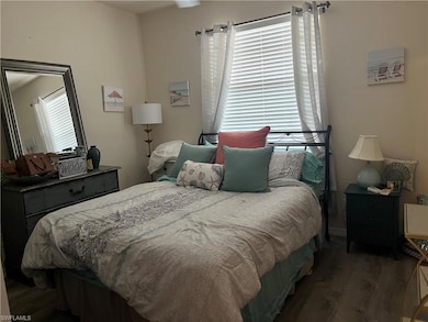 Bedroom with wood finished floors closet and priva