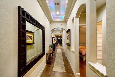 This is the view from the inside of the front entry; filled with tranquil wall tones and rich wood-look tile flooring(throughout), both beautiful and durable! It's the little things that make for tremendous enjoyment, like the arched theme, repeated throughout.