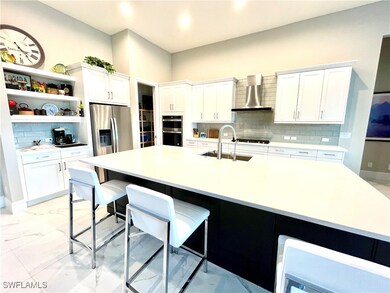 Kitchen with wall chimney exhaust hood, white cabi