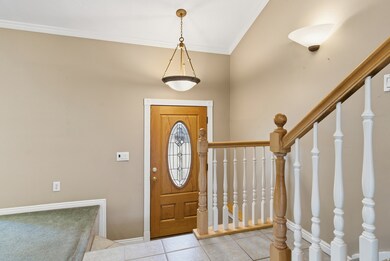 Entryway featuring stairway, tile patterned flooring, and ornamental molding