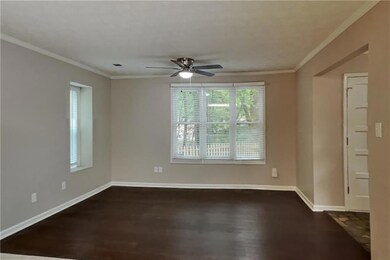 Unfurnished room with dark wood-style flooring, ceiling fan, baseboards, and ornamental molding