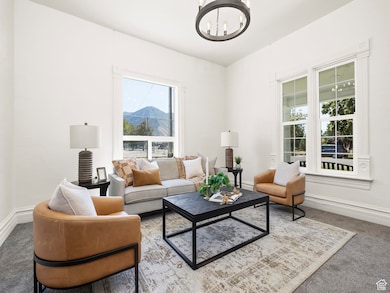 Living area with a chandelier, carpet flooring, and a mountain view