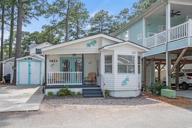 View of front of home with covered porch, a ceiling fan, and french doors