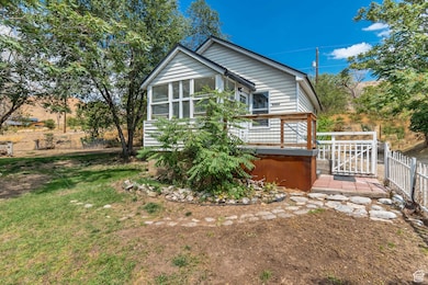 Back of house featuring a sunroom and a deck