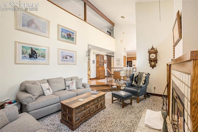 Living area with baseboards, a fireplace, beamed c