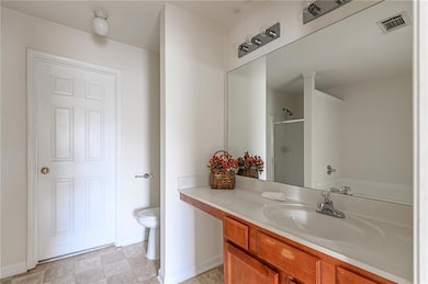 Full bathroom featuring a shower stall, vanity, toilet, and baseboards
