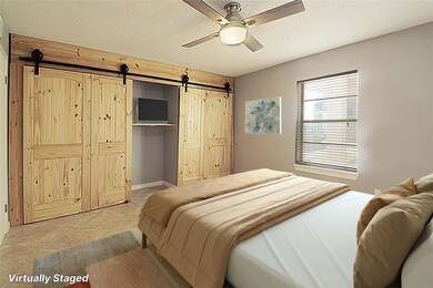 Spacious bedroom with beautiful barn doors over a full wall of closets