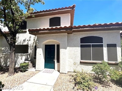 View of front of home with a tiled roof and stucco