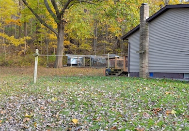 View of green lawn featuring a deck and a forest view
