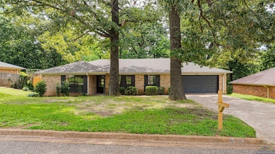 Ranch-style house featuring brick siding, concrete driveway, a garage, and a shingled roof