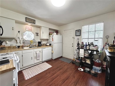 Kitchen of Unit 227 features an electric range/oven with a microwave. The refrigerator, washer, and dryer convey with the property.