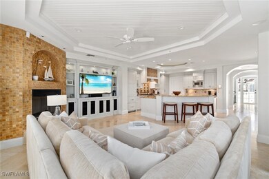 Living area with a tray ceiling, a ceiling fan, ar