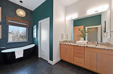 Bathroom featuring a soaking tub, baseboards, an 