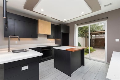 Kitchen with dark cabinets, black appliances, recessed lighting, and a center island