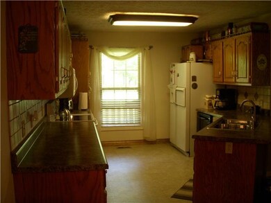 Large kitchen with lots of custom cabinets with new counter tops and new floor covering. All appliances stay.