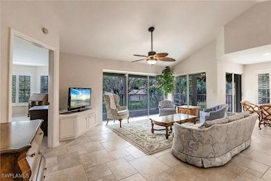 Living room featuring vaulted ceiling and ceiling fan