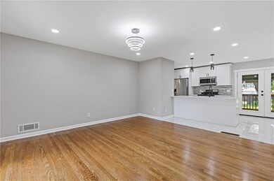 Unfurnished living room featuring recessed lighting, baseboards, light wood finished floors, french doors, and a chandelier