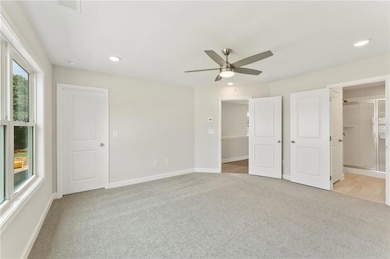 Large primary bedroom with ceiling fan.