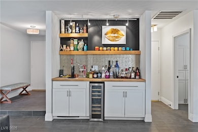 Bar featuring wine cooler, dark wood-style floors,